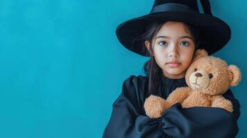 A young girl dressed as a witch hugs a teddy bear photo