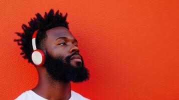 Man with Headphones Enjoying Music Against Red Wall photo