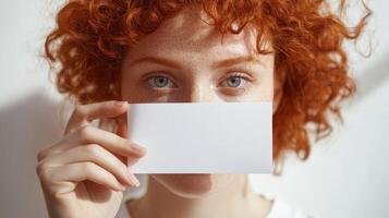 Redhead woman holding a blank white card photo