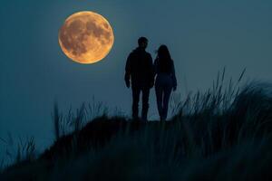 A couple standing on a hill with a full moon in the background photo