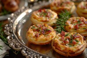 A silver platter topped with mini quiches photo
