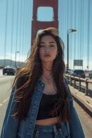 A woman in denim jacket standing in front of the golden gate bridge photo