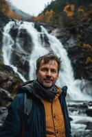 Man standing in front of waterfall in autumn photo