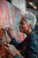 An older woman painting on a large canvas photo