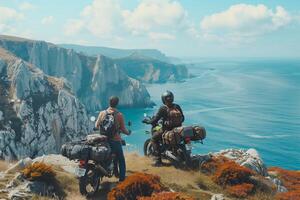 Two people on motorcycles looking at the ocean photo