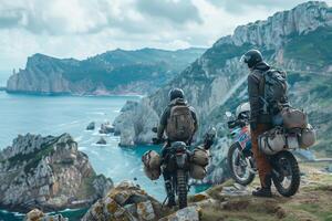 Two people on motorcycles looking out over the ocean photo