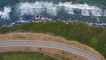 View from a drone vertically down on an empty asphalt road along the coast video