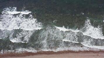 A view of the ocean and waves crashing against the rocky shore with white foam video