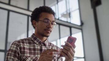 Smiling Man Browsing Smartphone in Modern Space video