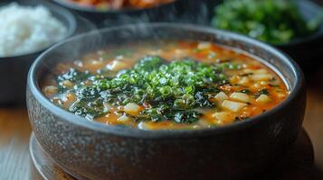 A steaming bowl of traditional Korean seaweed soup, with a side of rice and kimchi. 6 photo