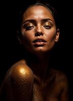 Portrait of a beautiful woman with golden makeup on a black background. Golden Goddess photo