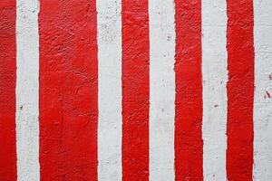 Textured Red and White Vertical Striped Wall with Weathered Paint Details for Creative Background photo