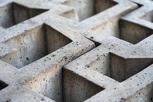 Closeup of Geometric Concrete Blocks with Symmetrical Patterns and Textured Surface in Natural Light photo