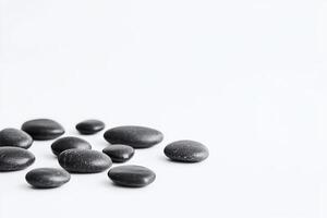Smooth Black Spa Stones on White Background for Wellness and Relaxation Concepts photo