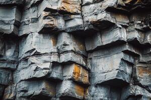 Natural Layered Rock Formation with Textured Gray and Orange Stone Surface in Cliff Landscape photo
