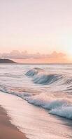 Serene Ocean Waves on Sandy Beach with Pastel Pink Sunset Sky and Gentle Clouds in the Background photo
