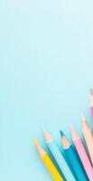 Bright Colored Pencils Arranged on Light Blue Background for Education and Creative Projects photo