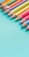 Close Up of Colored Pencils Arranged Diagonally on Light Blue Background for Creative Art Projects photo
