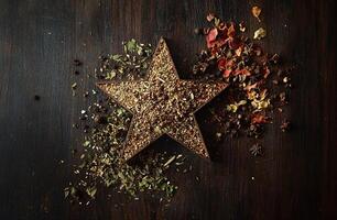 Rustic Star Shaped Spice Arrangement with Herbs and Dried Flowers on Dark Wooden Surface photo