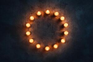 Circle of Warm Glowing Candles on Dark Rustic Background for Calm Peaceful Atmosphere photo