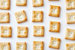 Golden Baked Square Crackers Arranged in Grid Pattern on White Background for Snack and Food Concepts photo