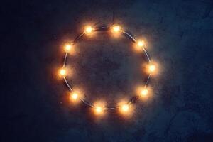 Glowing Warm String Lights in Circular Shape on Dark Textured Background for Festive Decoration photo