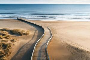 Wooden Boardwalk Leading Through Sand Dunes To Ocean With Clear Sky And Gentle Waves On Sunny Beach photo