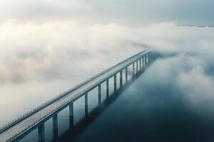 Long Elevated Bridge Stretching Over Calm Water Surrounded By Dense Morning Fog In Serene Landscape photo