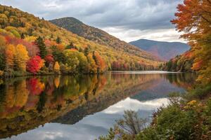 A lake surrounded by trees and mountains in the fall photo