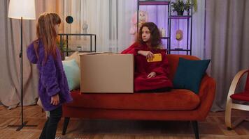 Little children girls siblings playing hide and seek, peekaboo game, hiding inside cardboard box video