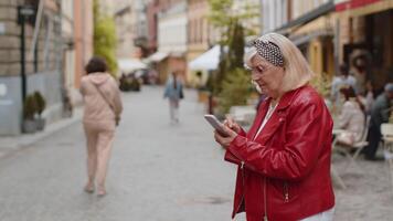 Tourist traveler senior woman using looking smartphone search a way on map in mobile navigator app video