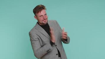 Stylish business man shouting, raising fists in gesture I did it, celebrating success, winning video