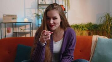 Pretty young woman smiling, pointing to camera, choosing lucky winner, indicating, inviting, approve video