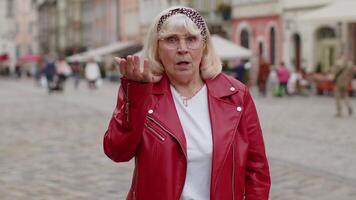 Surprised frustrated senior woman raising hands asking reason of failure, demonstrating disbelief video