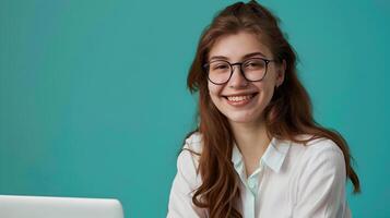 Young Female Communications Director Exuding Joy while Working on Laptop in Vibrant Office photo