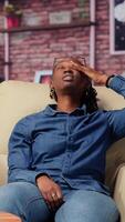 African american couple laying back on the couch and relaxing, feeling extremely tired and working under pressure. Sleepy people dealing with burnout and workload, freelancers with anxiety. Camera B. video