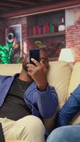 Exhausted people dealing with fatigue and anxiety in living room at home, being overwhelmed with their freelancing tasks and lack of help. Black couple stretching on the couch. Camera A. video
