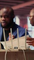 Black irritated man and woman rebooting their wireless router and checking network settings, feeling angry with the struggles to resolve an internet outage disrupting their tasks. Camera B. video