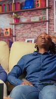 African american couple laying back on the couch and relaxing, feeling extremely tired and working under pressure. Sleepy people dealing with burnout and workload, freelancers with anxiety. Camera B. video