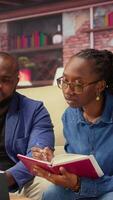 Mature people overseeing schedule and planning activities at coffee table, working on time management with online tools. Couple utilizing a notebooks and taking handwritten notes. Camera A. video