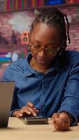 Worried African American woman looks at tax numbers on documents while her partner reassures her, helping with financial planning. Discussing ways to reduce expenses, save money. Camera A. video