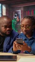 African american man and woman solving freelance tasks at home, working together on their phones to finish an important project for their employer. Networking with partners. Camera A. video