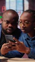 African american man and woman solving freelance tasks at home, working together on their phones to finish an important project for their employer. Networking with partners. Camera B. video