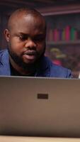 Black remote employees organizing calendar appointments using laptop and ledger, checking papers and synchronizing important tasks on schedule. Man and woman review files at home. Camera B. video