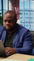 African american people spending time together at home with different activities, young man working and earning money while his girlfriend is scrolling websites on her smartphone. Camera A. video