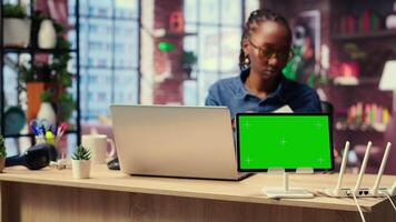 African American female freelancer browse troubleshooting guide next to copy space, working on debugging router issues to restore home network. Young woman struggles to solve tasks. Camera B. video