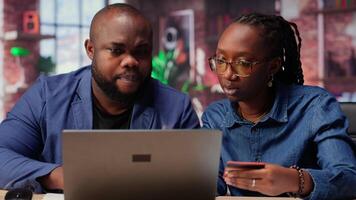 Relaxed people entering card numbers to verify the balance before paying online, e commerce on webpages at home. Couple making web transactions and transferring money. Shopping. Camera B. video