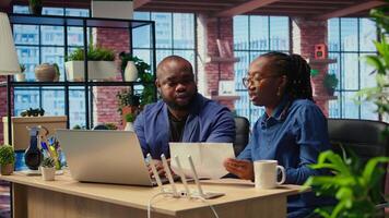 African American couple at home office troubleshooting their Wi Fi modem and discussing solutions to fix a weak connection affecting their remote work productivity. Router guide files. Camera A. video