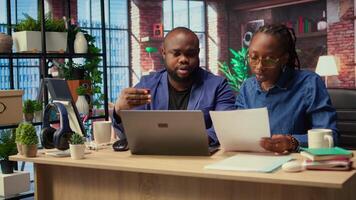 African american people at home entering card digits to renew an account subscription, managing streaming services on laptop. Couple transferring money, updating the credentials. Camera A. video