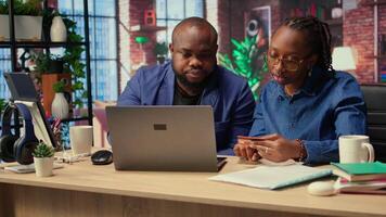 Young people using a card to check the financial balance before buying or paying something, e commerce from the home office. African american couple doing web transactions. Camera A. video